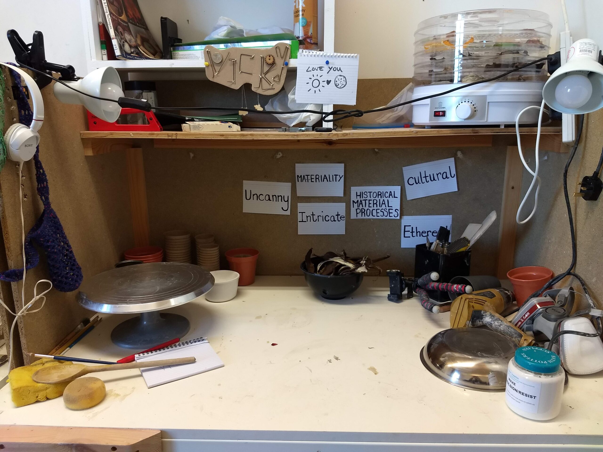 An image of Vicky's workspace. There is a large desk holding various ceramic tools.